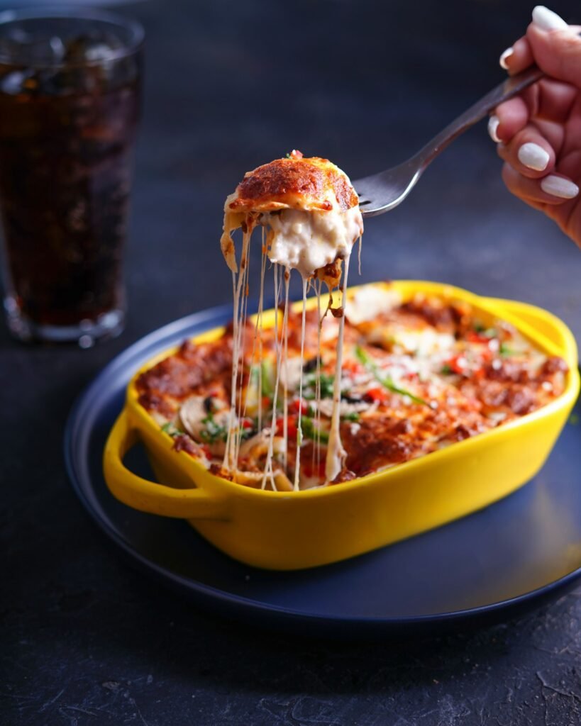 Cheesy baked lasagna in a baking dish with melted mozzarella