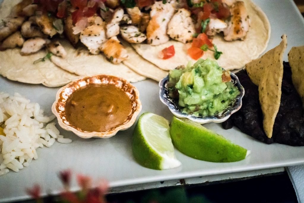 Chicken fajitas with grilled chicken, lime wedges, guacamole and salsa for easy meal prep bowls