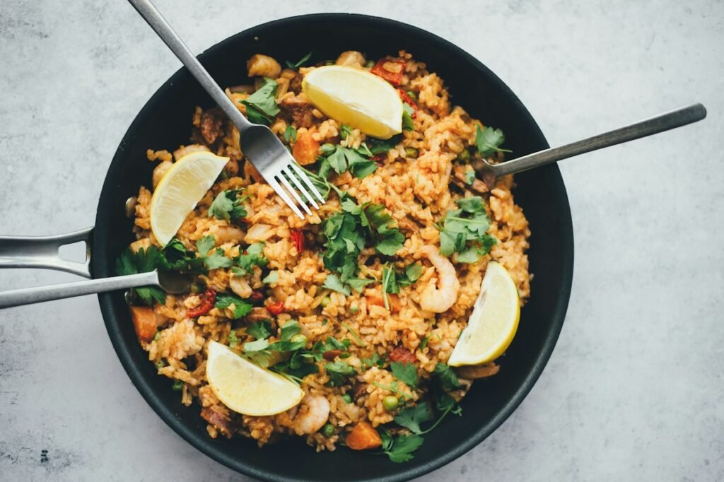 Chicken fried rice served in a black bowl with lemon