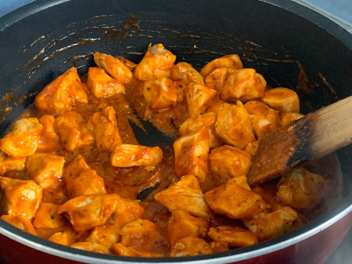 Fajita seasoned chicken pieces cooking in a skillet
