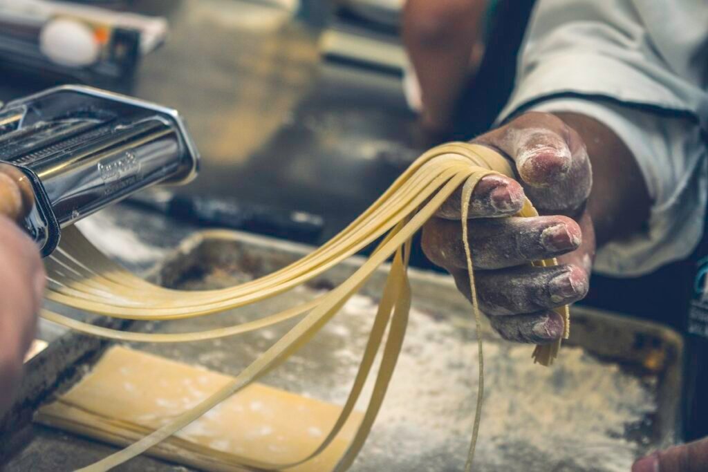 Fresh homemade pasta coming out of a pasta machine