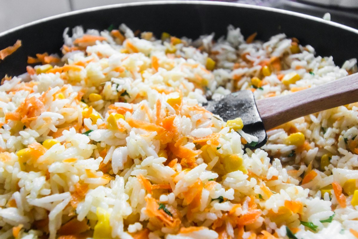 Fried rice cooking in a hot black pan