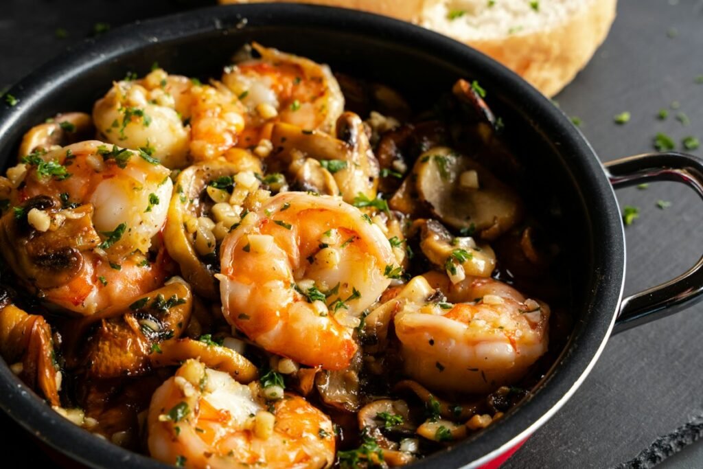 Garlic butter shrimp cooking in a cast iron pan