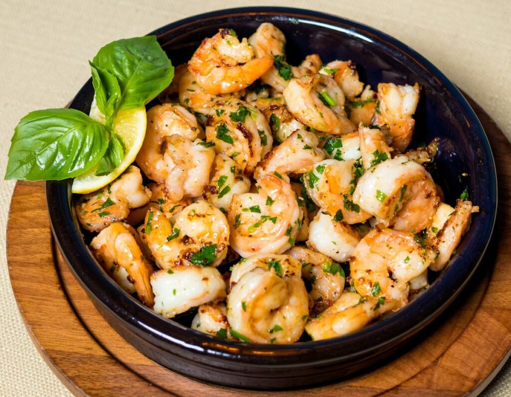 Garlic butter shrimp in a skillet with fresh basil