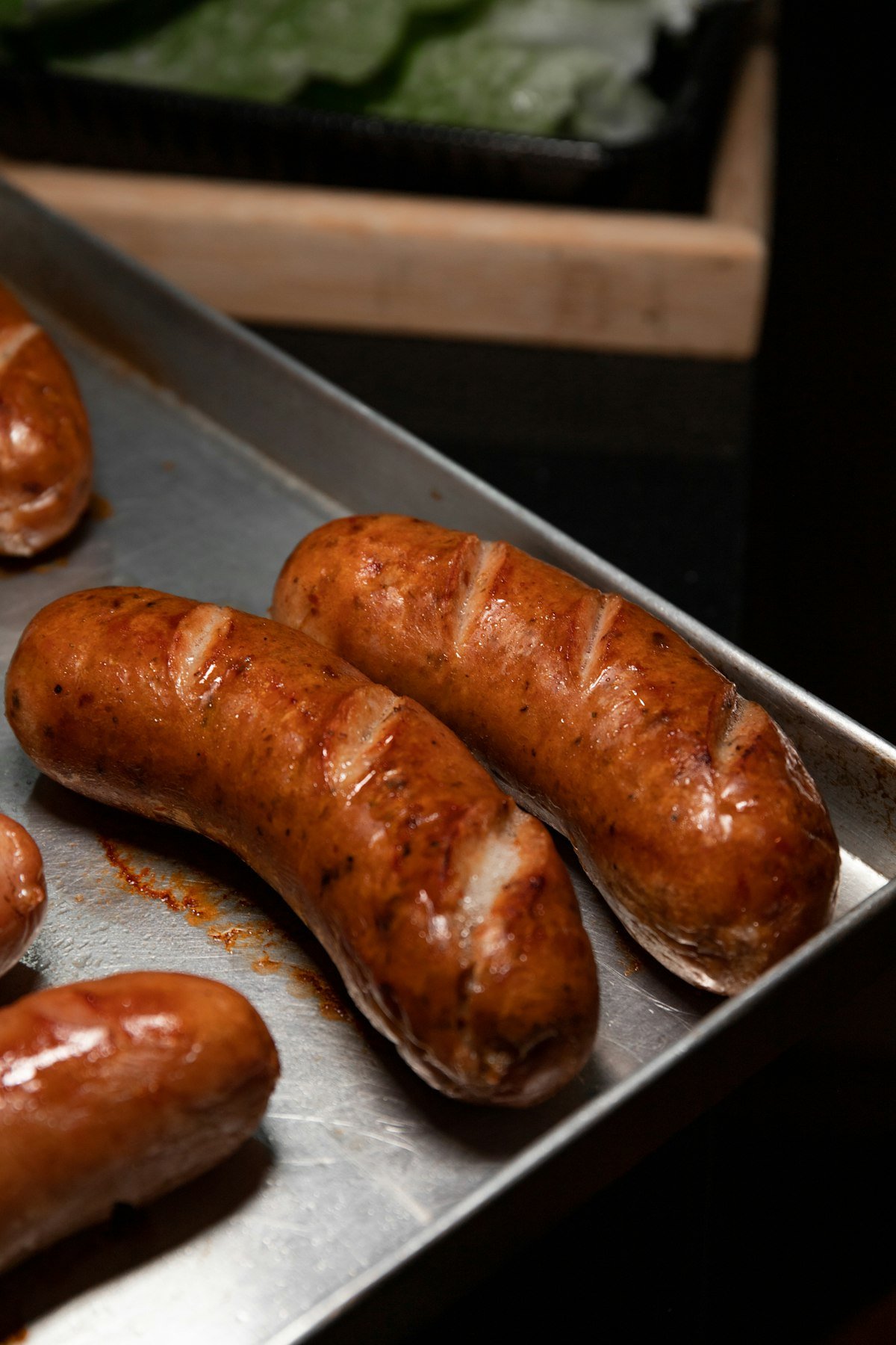Browned Italian sausage links roasted on a metal sheet pan