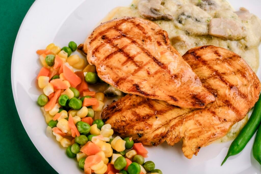 Juicy air fryer chicken breast with grill marks served with vegetables