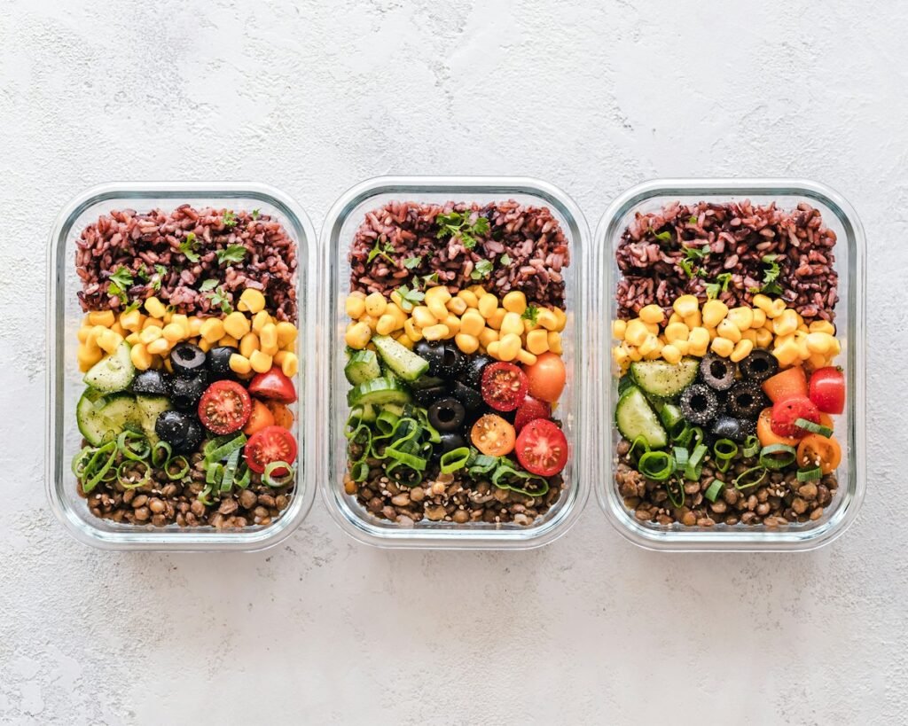 Meal prep containers filled with rice, beans and vegetables