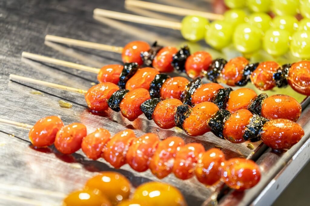 Rows of homemade tanghulu fruit skewers on a tray